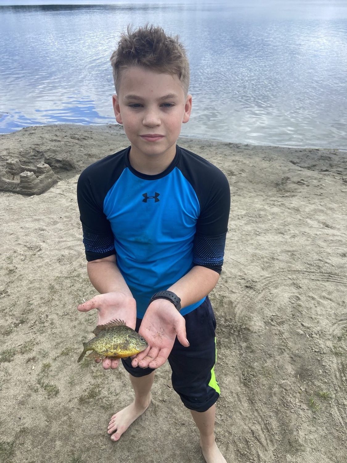 Thomas holding a fish he caught at the lake