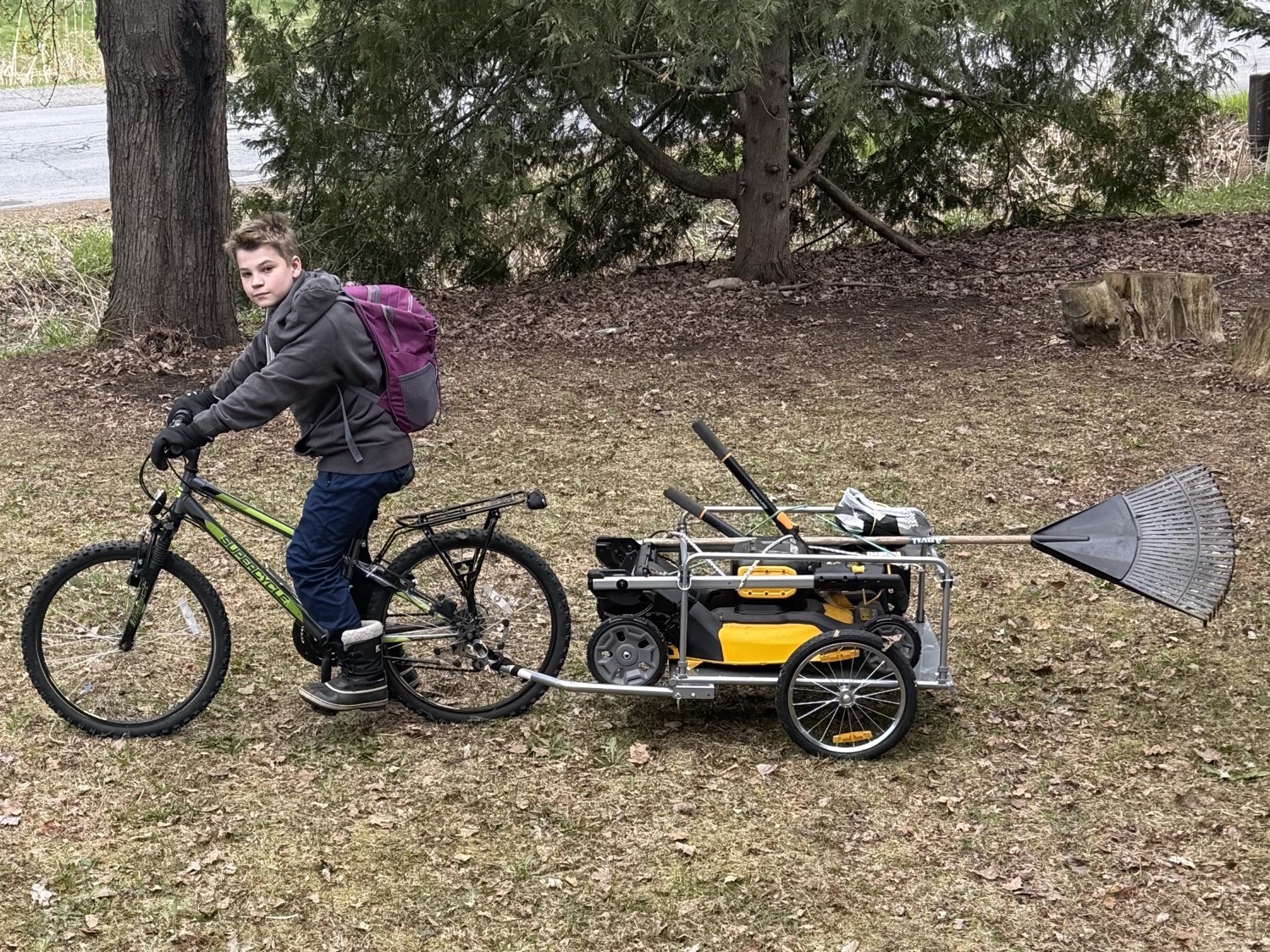 Thomas on his business bike towing a mower trailer